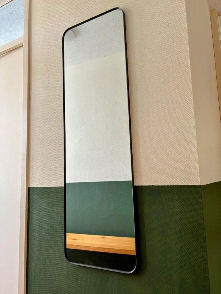 Wall mirror securely mounted in hallway